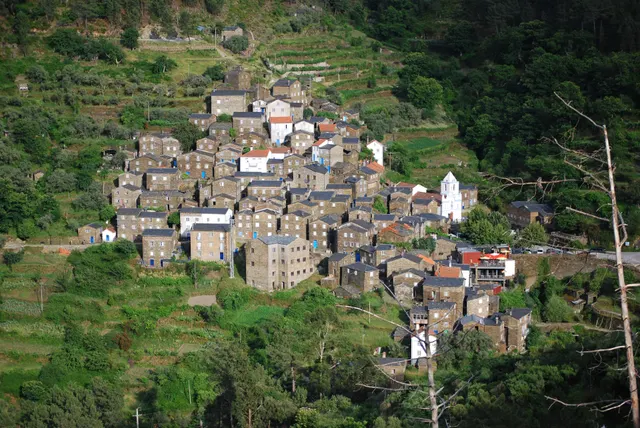 Grey schist houses of Piódão climbing the hillside with the white parish church in the centre